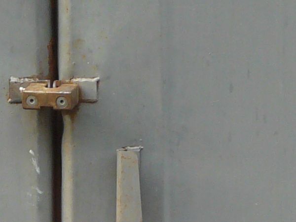 Heavy grey metal doors with lock in center and rusting edges.